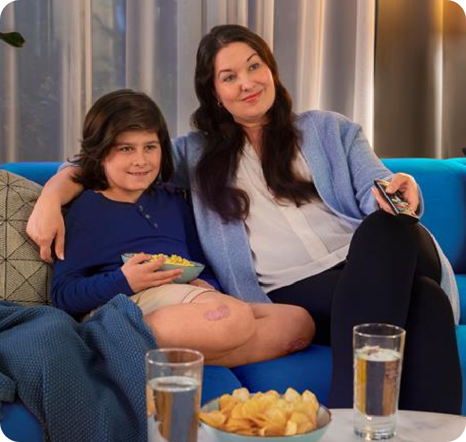 Parent and child watching TV on couch